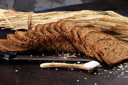 bread cutted on board from above. Kitchen or bakery poster design on dark.
