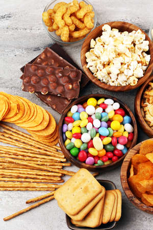 Salty snacks. Pretzels, chips, crackers in wooden bowls. Unhealthy products. food bad for figure, skin, heart and teeth. Assortment of fast carbohydrates food. の写真素材