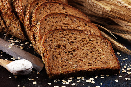 bread cutted on board from above. Kitchen or bakery poster design on dark.の写真素材