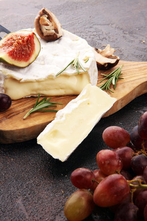 Camembert cheese and rosemary on rustic table