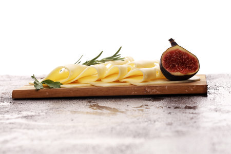 cheese slices on wooden tray with parsley. cheese with wholeの写真素材