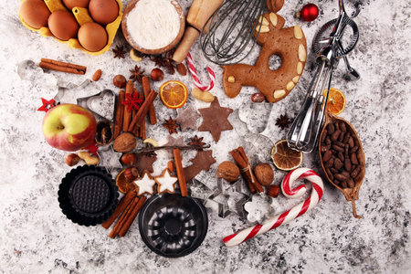 Christmas cookies and spices on rustic background with ingredients for xmas