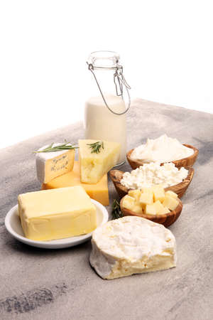 Different fresh dairy products on rustic background with milk, cheese, butter and cottageの写真素材