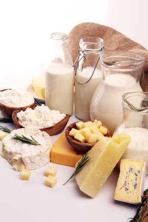 Different fresh dairy products on rustic background with milk, cheese, butter and cottageの写真素材