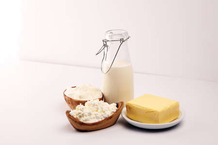 Different fresh dairy products on rustic background with milk, cheese, butter and cottageの写真素材