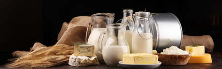Different fresh dairy products on rustic background with milk, cheese, butter and cottageの写真素材