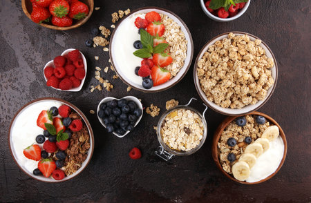 Tasty homemade granola served on table. Healthy breakfast with a bowl of oatmeal with banana, blueberries, raspberries and healthy food for Breakfastの写真素材