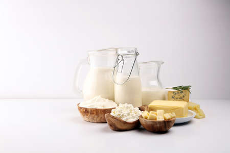 Different fresh dairy products on rustic background with milk, cheese, butter and cottageの写真素材