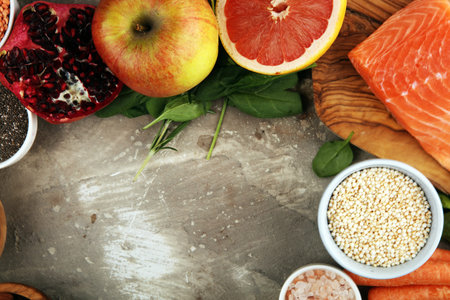 Healthy food clean eating selection: fish, fruit, vegetable, cereal, leaf vegetable on background
