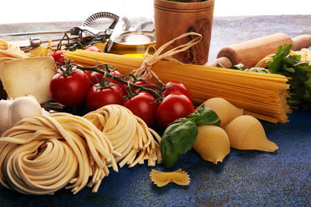 Pasta, vegetables, herbs and spices for Italian food on tableの写真素材