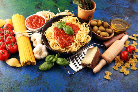 Tasty appetizing classic italian spaghetti pasta with tomato sauce, cheese parmesan and basil with ingredientsの写真素材