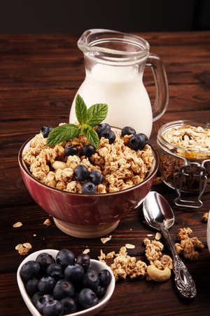 Tasty homemade granola served on table. Healthy breakfast with a bowl of oatmeal with banana, blueberries, raspberries and healthy food for Breakfastの写真素材