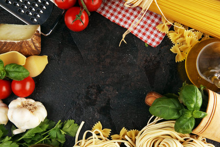 Pasta, vegetables, herbs and spices for Italian food on tableの写真素材