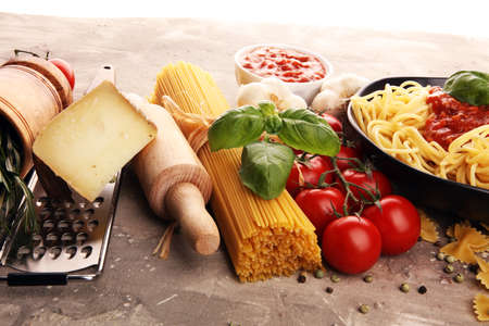 Tasty appetizing classic italian spaghetti pasta with tomato sauce, cheese parmesan and basil with ingredientsの写真素材