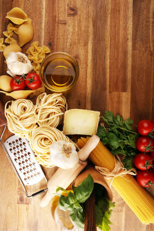 Pasta, vegetables, herbs and spices for Italian food on tableの写真素材