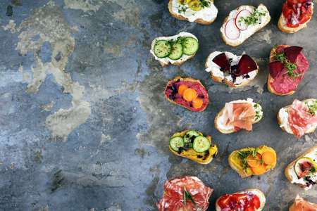 Assorted bruschetta with various toppings. Appetizing bruschetta or brie crostini. Variety of small sandwiches. Mix bruschettaの写真素材