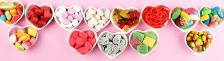 candies with jelly and sugar. colorful array of different childs sweets and treats on pinkの写真素材