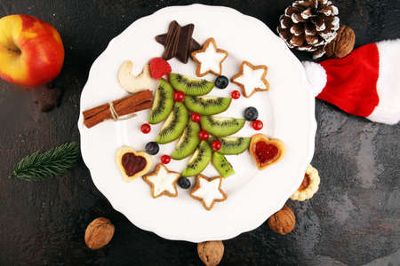 Funny edible Christmas tree, Christmas breakfast idea for kids. Beautiful Christmas and New Year food background with kiwi fruitの写真素材