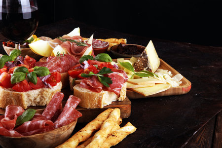 Italian antipasti wine snacks set. Cheese variety, Mediterranean olives, pickles, Prosciutto di...