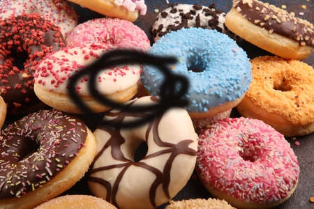 assorted donuts with chocolate frosted, pink glazed and sprinkles donuts. carnival concept with sugarの写真素材