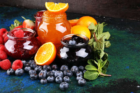 assortment of jams, seasonal berries, plums, mint and fruits, tangerine marmeladeの写真素材