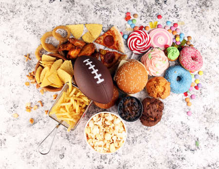 chicken wings, fries, and onion rings for football on a table. Great for Bowl football Game. and other unhealthy food with salt, fat and sugarの写真素材