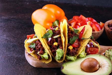 Mexican tacos with beef, tomatoes, avocado, chilli and onions 