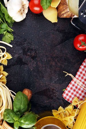 Pasta, vegetables, herbs and spices for Italian food on tableの写真素材