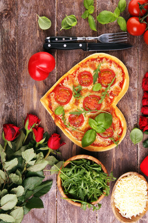 pizza Heart shaped margherita with tomatoes and mozzarella vegetarian. Food concept of romantic love for Valentines Day.の写真素材
