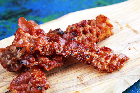 Closeup of slices of crispy hot freshly cooked bacon