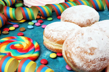 Carnival powdered sugar raised donuts with paper streamers. German berliner or krapfenの写真素材