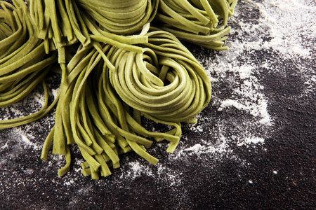 Closeup of raw fresh homemade green pasta tagliatelle. fresh italian traditional raw pasta