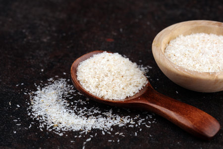 Portion of Psyllium Seeds on rustic background. Psyllium seed husks on wooden