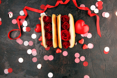 hot doc for valentines day with red roses and hearts. Festive burger for Valentine's day. Romantic...