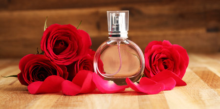 Bottle of perfume with flowers on rustic background. Cosmetic aroma concept