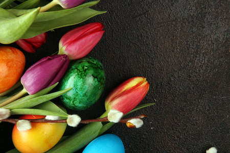Easter eggs and tulips and daffodils on rustic background. Springtime decoration for easterの写真素材