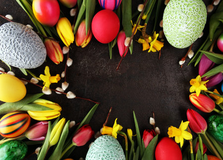 Easter eggs and tulips and daffodils on rustic background. Springtime decoration for easter