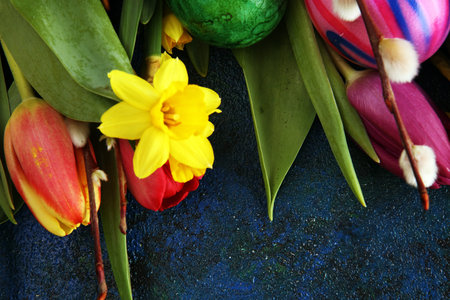 Easter eggs and tulips and daffodils on rustic background. Springtime decoration for easterの写真素材