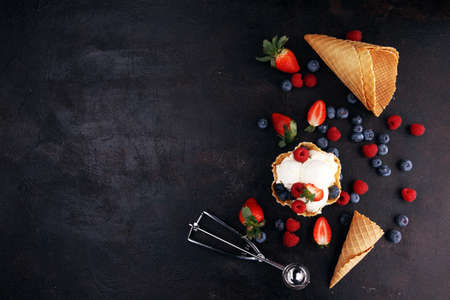 Vanilla ice cream scoops with fresh berries on tableの写真素材