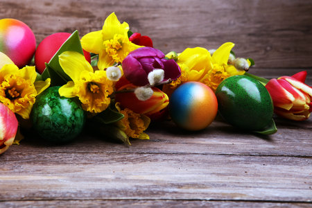 blooming daffodils and easter eggs for spring decoration on rustic background