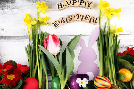 Happy Easter wooden letter. Holiday concept design. Happy Easter flat lay with flower and eggs in beatiful colors.の写真素材