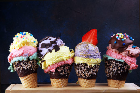 Colorful ice cream cone, rainbow jimmies, chocolate and strawberry toppings floating. Ice cream...