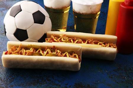hot dogs with mustard and ketchup on the table with draft beer for football soccer party.の写真素材