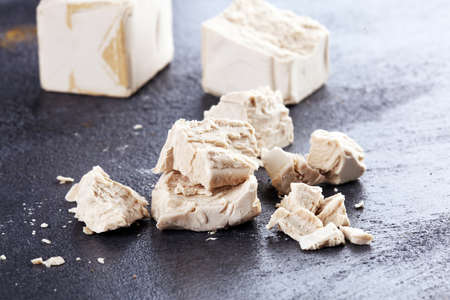 Dry yeast crumbled and yeast block for baking on tableの写真素材