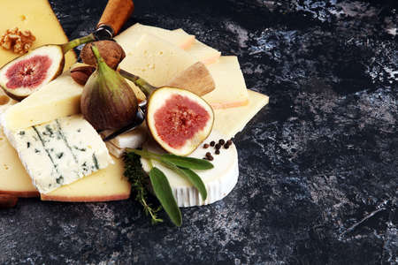 Cheese plate served with figs, various cheese on a platter on rustic tableの写真素材