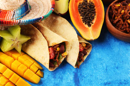 Mexican food mix in colorful colors. sombrero and mexican food with tacos tortillasの写真素材