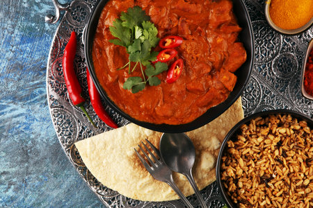 Chicken tikka masala spicy curry meat food in pot with rice and naan bread. indian food with chicken...