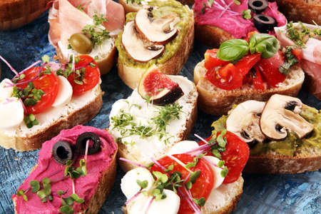 Assorted bruschetta with various toppings. Appetizing bruschetta or crudo crostini. Variety of small sandwiches. Mix bruschettaの写真素材