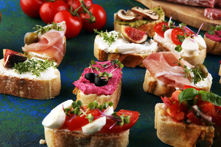 Assorted bruschetta with various toppings. Appetizing bruschetta or crudo crostini. Variety of small...