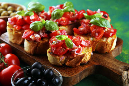 Bruschettas on cutting board on rustic background with tomatoesの写真素材